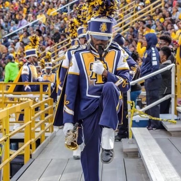 Michael Austin Jr. marching with saxophone in the North Carolina A&T Blue and Gold Marching Machine